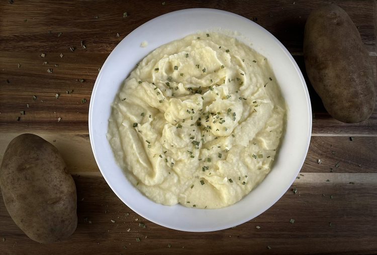 mashed potatoes with chives on cutting board